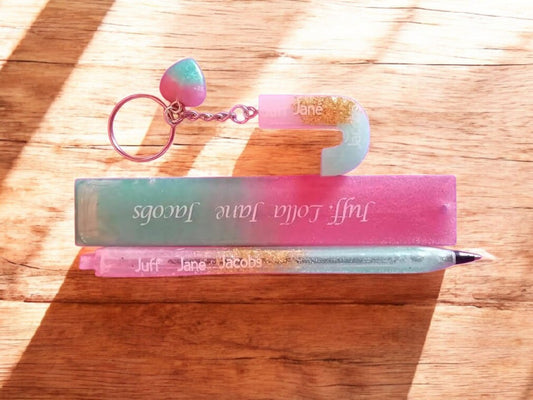 Misty Crafts Designs personalised resin pen and keychain set in pink and teal gradient with gold glitter accents.
